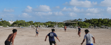Jaunieši spēlē futbolu smilšainā laukumā Klusā okeāna salā Nauru, kur futbols tikai sāk attīstīties.