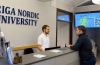 Rīgas Ziemeļvalstu augstskolas reģistratūra, kur apmeklētājs saņem informāciju par studiju iespējām.